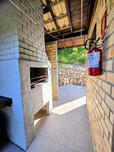 a brick oven on a wall with a fire extinguisher at CalaRosa Condomínio in Praia do Rosa