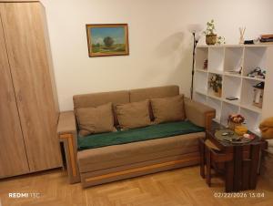 a couch in a living room with a table at Apartman Vuk in Obrenovac