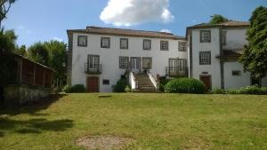 a large white building with stairs in a yard at Casa de Nossa Senhora da Piedade in Ponte de Lima