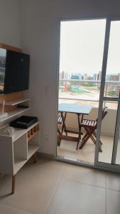 a room with a table and a glass window at Apartamento Cabedelo João Pessoa in Cabedelo