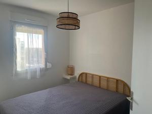 a bedroom with a bed and a window at appartement vue mer in Frontignan