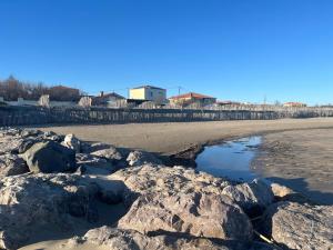 a beach with rocks and water on the sand at appartement vue mer in Frontignan