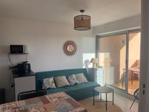 a living room with a green couch and a table at appartement vue mer in Frontignan