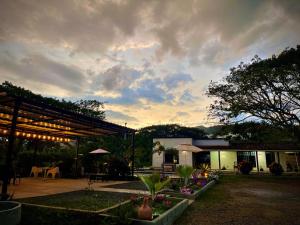 a building with a patio with a table and umbrella at Finca el origen in Roldanillo