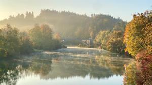 a bridge over a river with trees and a bridge at Ferienwohnung Schmid Lautrach im Illerwinkel in Lautrach