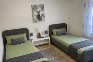 a bedroom with two beds and a picture on the wall at Ferienwohnung Schmid Lautrach im Illerwinkel in Lautrach