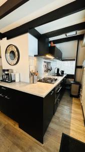 a kitchen with black cabinets and a counter top at Villa Edice met zwembad en restaurant in Durbuy - honden toegelaten in Durbuy