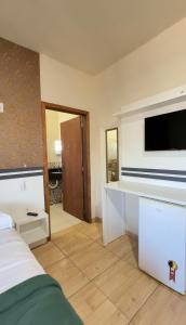 a bedroom with a bed and a flat screen tv at Pousada Fielder e Anacleto in Penha