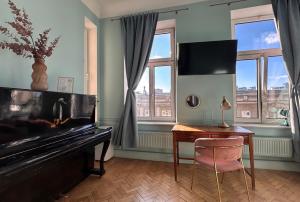 a living room with a piano and a desk and window at 4th Floor Bed and Breakfast in Warsaw