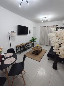 a living room with a tv and a table and chairs at Departamento a 3 min de Playa Miramar in Ciudad Madero