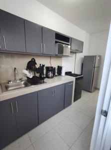 a kitchen with blue cabinets and a sink and refrigerator at Departamento a 3 min de Playa Miramar in Ciudad Madero