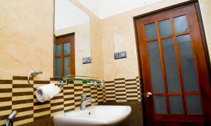 a bathroom with a sink and a mirror and a door at Ella Chalana Dew In in Ella +150 photos