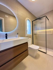 a bathroom with a sink and a toilet and a mirror at Montgo Home in Jávea