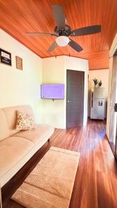 a living room with a couch and a ceiling fan at M&M Container Home in Sardinal