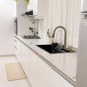 a kitchen with white cabinets and a sink at Nuwan Home Vacation Villa in Wennappuwa