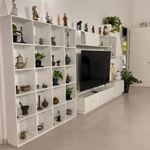 a living room with a tv and shelves with plants at Nuwan Home Vacation Villa in Wennappuwa