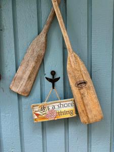 two wooden spatulas and a sign hanging on a wall at Sea 'N' Stars BNB in Gabriola