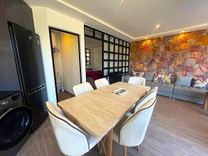 a dining room with a wooden table and white chairs at DreamCatcher Paragliders in Tamelalt