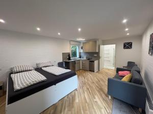a bedroom with a bed and a couch and a kitchen at Königshof Studio in Monschau