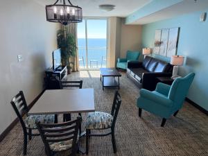 a living room with a couch and a table and chairs at Towers at North Myrtle Beach in Myrtle Beach