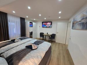 a bedroom with two beds and a table and a television at Apartment an der Prims Nalbach in Nalbach