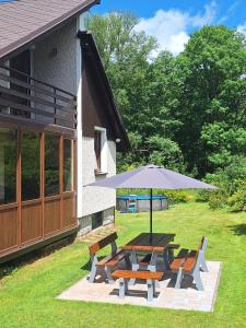 stół piknikowy i parasol obok domu w obiekcie Chalupa Ferdinandov w mieście Liberec