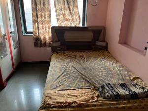 a small bedroom with a bed in a room at Prakash Banglow in Malvan