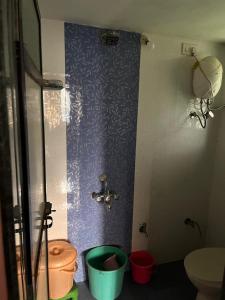 a bathroom with a toilet and a faucet at Prakash Banglow in Malvan