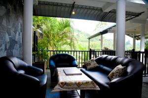 a patio with two leather chairs and a table at Ella Chalana Dew In in Ella