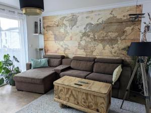 a living room with a couch and a map on the wall at Appartement 2 Chambres INDIaNA Hyper centre in Vitré