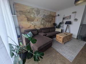 a living room with a couch and a wooden wall at Appartement 2 Chambres INDIaNA Hyper centre in Vitré +20 photos