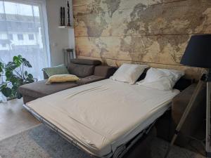 a bed and a couch in a room at Appartement 2 Chambres INDIaNA Hyper centre in Vitré