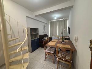 a dining room with a table and chairs and a living room at Apes Raizes Douradas in Campinas