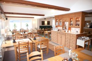 a dining room with wooden tables and chairs at Hotel Mellum in Wangerland