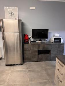 a kitchen with a stainless steel refrigerator and a tv at Home Sicilia in Carini