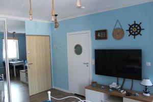 a living room with a tv and a blue wall at U Rudobrodego in Pogórze