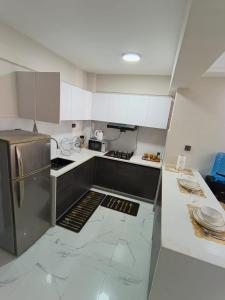 a kitchen with white cabinets and a stainless steel refrigerator at Lyon in Nairobi