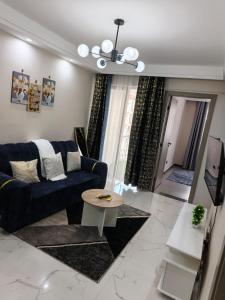 a living room with a blue couch and a table at Lyon in Nairobi +2 photos