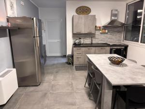 a kitchen with a stainless steel refrigerator and a table at Home Sicilia in Carini