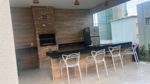 a kitchen with a bar with stools and a counter at Apartamento Cabedelo João Pessoa in Cabedelo