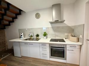 a white kitchen with a sink and a stove at Apartment Mira 13 in Pulheim +3 photos