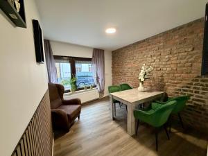 a living room with a table and chairs and a brick wall at Apartment Mira 13 in Pulheim