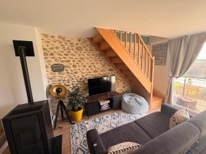 a living room with a couch and a staircase at Bel-Air des Collines in Saint-Martin-dʼAoût