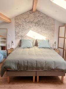 a bedroom with a large bed with blue pillows at Bel-Air des Collines in Saint-Martin-dʼAoût +42 photos