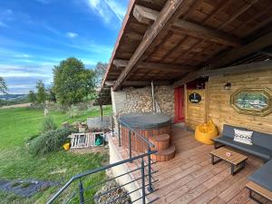 a wooden deck with a hot tub and a grill at Bel-Air des Collines in Saint-Martin-dʼAoût