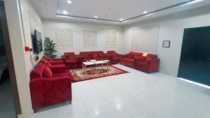 a living room with red couches and a table at شاليهات تولين 2 in Taif