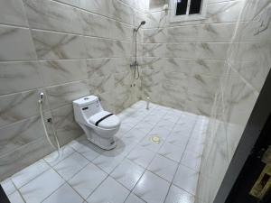 a white bathroom with a toilet and a shower at شاليهات تولين 2 in Taif