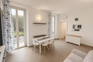 a white living room with a table and chairs at Moderno appartamento a 2 passi dal centro in Brescia +21 photos