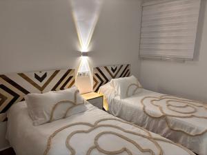 a bedroom with two beds and a lamp on a table at Apartamento Maruchi in Santa Cruz de Mudela