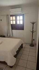 a bedroom with a white bed and a window at Casa Meão in Recife